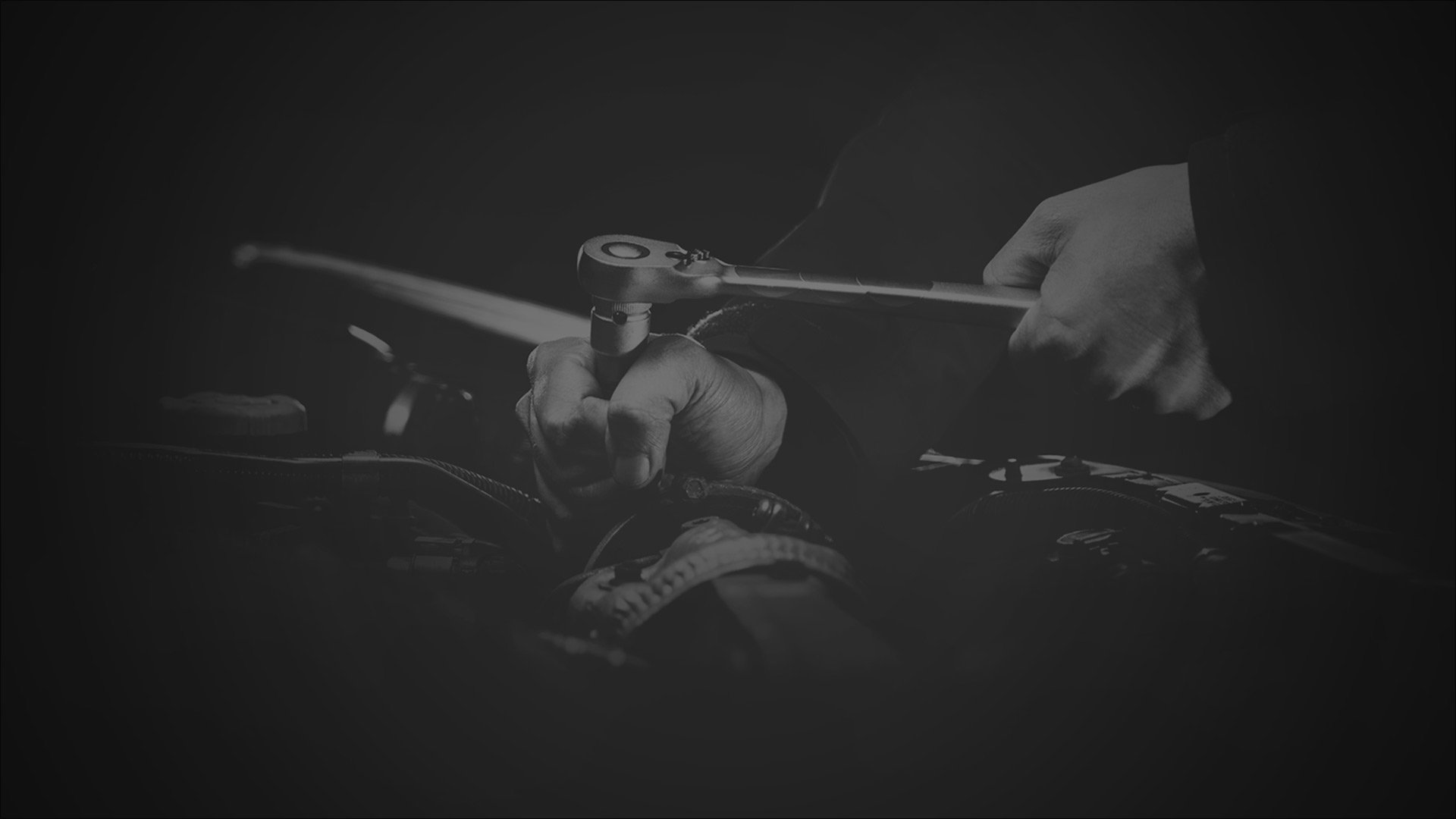 A person gripping a wrench, focused on their hands and the tool.
