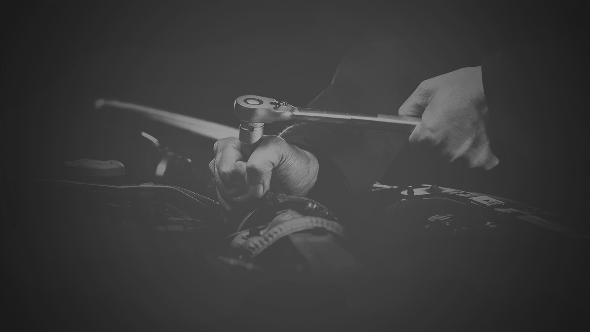 A person gripping a wrench, focused on their hands and the tool.